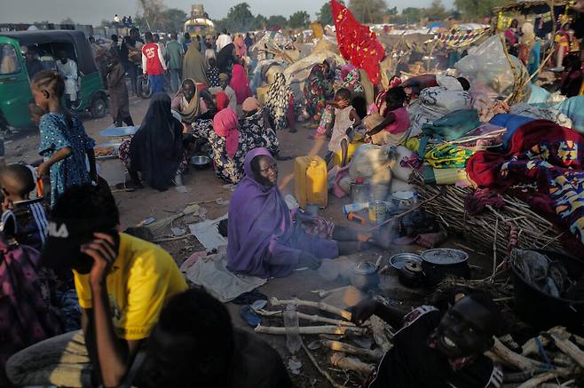 19일 수단 다르푸르주의 분쟁을 피해 이웃국가 차드의 한 임시대피소로 피난해온 이들이 끼니를 해결하기 위해 길에서 불을 피우고 있다. 로이터 연합뉴스