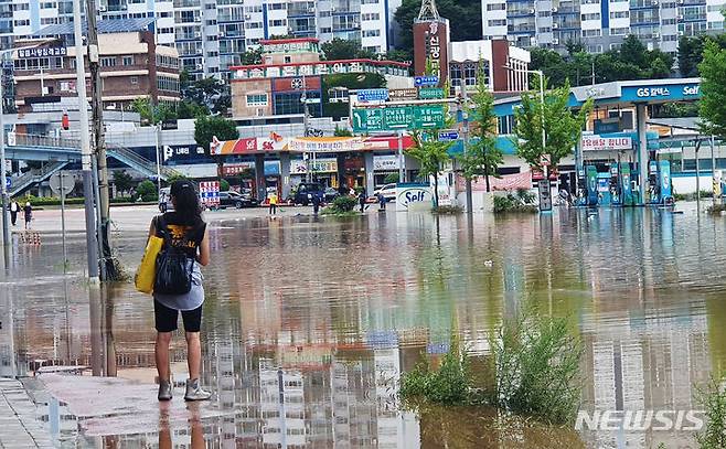 [목포=뉴시스] 박상수 기자 = 24일 오전 전남 목포시 석현동 일대가 침수되면서 한 주민이 물로 길이 막힌 도로를 바라보고 있다. 2023.07.24. parkss@newsis.com