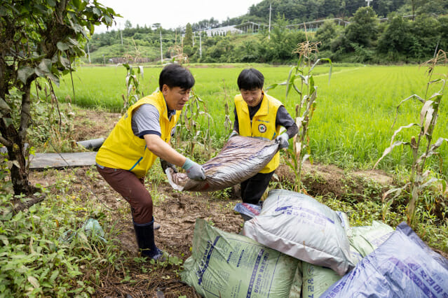 서부발전 직원들이 가축 사료 포대를 정리하는 장면.