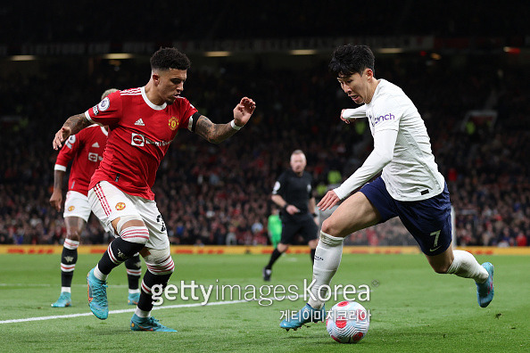 MANCHESTER, ENGLAND - MARCH 12: Jadon Sancho of Manchester United looks on as Heung-Min Son of Tottenham Hotspur controls the ball during the Premier League match between Manchester United and Tottenham Hotspur at Old Trafford on March 12, 2022 in Manchester, England. (Photo by Naomi Baker/Getty Images)