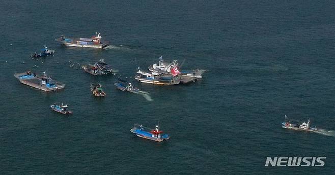 [보성=뉴시스] 변재훈 기자 = 26일 오후 전남 보성군 회천면 앞 바다에서 어선들이 욱일기를 단 채 후쿠시마 오염수 모형을 방류하는 선박을 에워싸는 해상 시위를 펼치고 있다. 2023.07.26. wisdom21@newsis.com