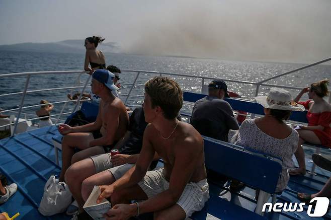 25일(현지시간) 그리스 로도스 섬 겐다니에서 산불을 대피하기 위해 관광객들이 페리를 타고 코르푸 섬으로 대피하고 있다. 2023.07.25. ⓒ AFP=뉴스1 ⓒ News1 우동명 기자