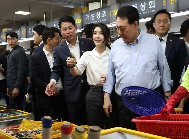 윤석열 대통령과 함께 부산을 찾은 김건희 여사가 27일 부산 자갈치시장에서 수산물을 살펴보다 새우를 직접 집어보고 있다. 연합뉴스