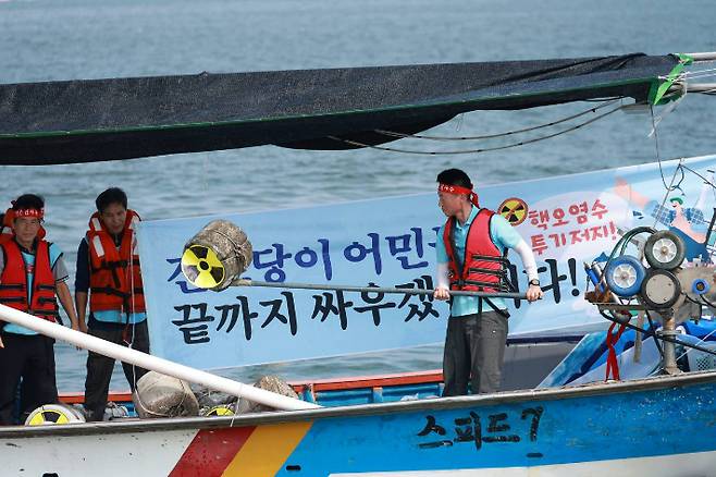 이성수 위원장이 바다에서 퍼포먼스를 하고 있다. 진보당 전남도당 제공