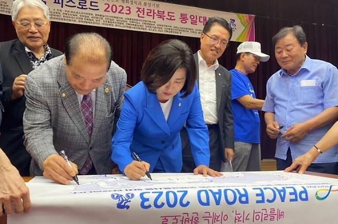 28일 오후 전북도청 대회의실을 열린 ‘신통일한국 피스로드 2023 전북 통일대장정’ 행사에서 주요 참석자들이 '피스로드 2023' 배너에 사인하고 있다. 전주=김동욱 기자