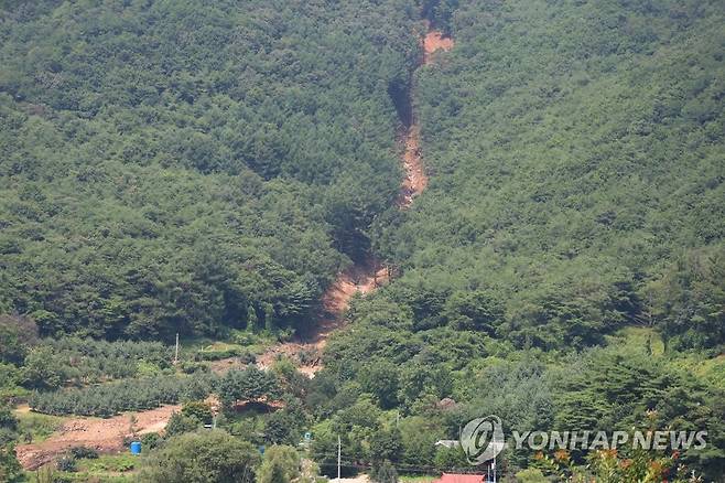 산사태로 무너진 산비탈 (영주=연합뉴스) 박세진 기자 = 30일 경북 영주시 풍기읍 욱금리 한 산비탈이 최근 계속된 집중 호우로 발생한 산사태로 인해 무너져있다. 현장에서는 복구 작업이 진행 중이다. 2023.7.30 psjpsj@yna.co.kr