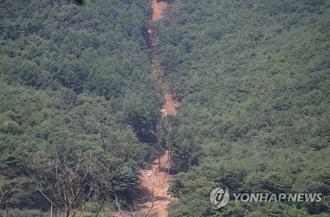 산사태로 무너진 산비탈 (영주=연합뉴스) 박세진 기자 = 30일 경북 영주시 풍기읍 욱금리 한 산비탈이 최근 계속된 집중 호우로 발생한 산사태로 인해 무너져있다. 현장에서는 복구 작업이 진행 중이다. 2023.7.30 psjpsj@yna.co.kr