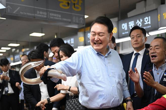 윤석열 대통령이 지난 달 27일 부산 중구 자갈치시장에서 장어를 직접 손으로 잡아 보고 있다. ⓒ연합뉴스