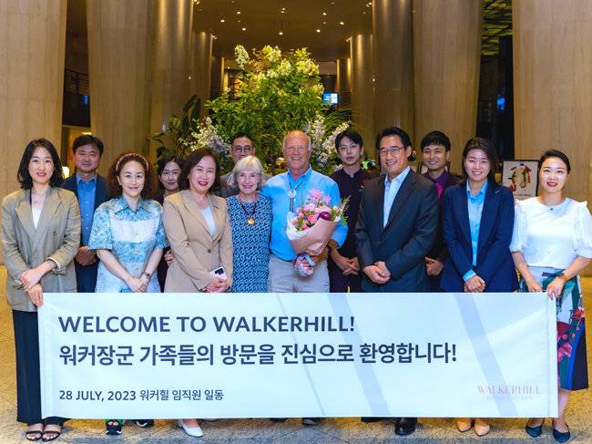 7월 말 서울 광장동 워커힐 호텔을 방문한 '6·25 전쟁 영웅' 고(故) 워커 장군의 손자 샘 워커 2세 부부(가운데)가 워커힐 임직원들과 기념 촬영을 하고 있다. [SK 제공]