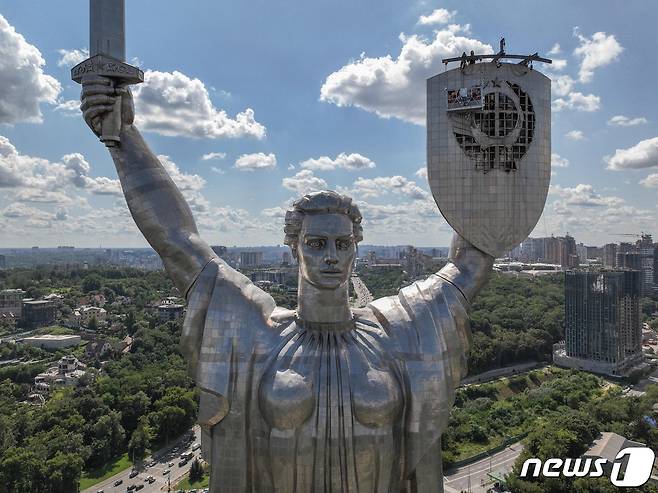 1일(현지시간) 우크라이나 수도 키이우에서 작업자들이 전쟁 박물관에 설치된 '조국 기념비'에서 구 소련의 상징물인 낫과 방패를 철거하고 있다. ⓒ AFP=뉴스1 ⓒ News1 김성식 기자