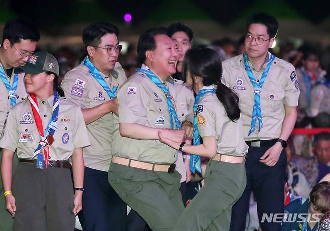 [부안=뉴시스] 전신 기자 = 윤석열 대통령이 2일 전북 부안군 새만금 일대에서 열린 2023 새만금 제25회 세계스카우트잼버리 개영식에서 6개국 스카우트 대원 선서 때 일어나며 부인 김건희 여사의 도움을 받고 있다. 2023.08.02. photo1006@newsis.com