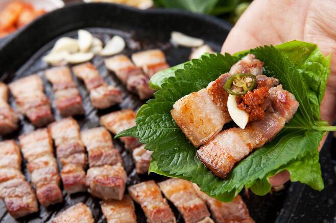 삼겹살은 비계 등 기름진 부위가 많은 부위다. 혈액-혈관 건강에 좋지 않고 비만의 원인이 되는 포화지방산이 많다. 유해 물질을 줄이는 마늘·양파·상추 등 채소와 함께 먹는 게 좋다. [사진=게티이미지뱅크]