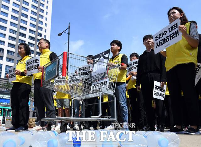 코스트코 마트노동자들이 2일 오전 경기도 광명시 코스트코 본사 앞에서 근무 중 온열질환으로 사망한 고 김동호 씨의 49재 추모집회를 하며 회사의 사과와 재발방지 대책을 촉구하고 있다. 바닥에는 사측이 제공했다가 일부 참가자들이 내던진 생수가 놓여 있다.