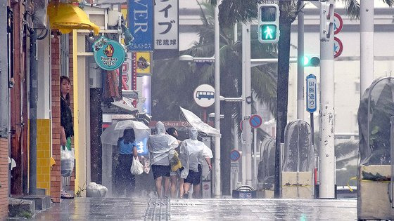 일본 오키나와 서남부 해상에서 올라온 태풍 '카눈'의 영향으로 2일 오키나와에 많은 비와 강풍이 불었다. 힘겹게 거리를 걷고 있는 오키나와 현 주민들의 모습. EPA=연합뉴스