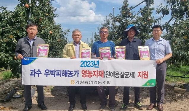 경남 거창농협 신중갑 조합장(왼쪽 두번째)이 우박 피해를 본 과수 농가에 영농자재를 무상으로 전달하고 있다.