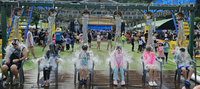 ▲ 평창 더위사냥 축제를 찾은 관광객들이 대형 물줄기가 쏟아 지는 물대포를 맞으며 더위를 식히고 있다.  전만천 객원기자