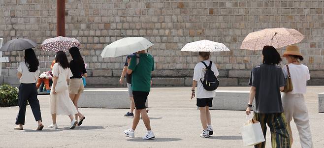 “요즘엔 남자들이 양산 쓰고 다녀도 이상하지 않아요” 무더위가 이어진 3일 서울 종로구 삼청동길에서 시민들이 강한 햇빛을 막기 위해 양산을 쓰고 이동하고 있다. 연합뉴스