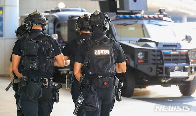 [제주=뉴시스] 우장호 기자 = '묻지마 흉기 난동' 사건 발생으로 경찰이 특별치안활동을 선포한 가운데 6일 오전 제주국제공항 1층 도착장에서 소총과 권총 등 화기로 무장한 제주경찰특공대 대원들이 장갑차를 대동해 경계 활동을 하고 있다. 2023.08.06. woo1223@newsis.com