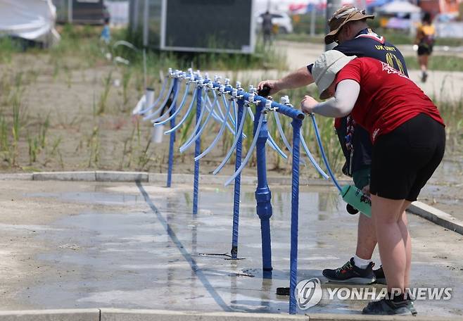 물이 필요한 폭염 사진은  2023 새만금 세계스카우트잼버리 개영일인 지난 2일 전북 부안군 하서면 야영장 델타구역에 마련된 수도시설에서 참가자가 물을 따르고 있는 모습.[연합뉴스 자료사진]