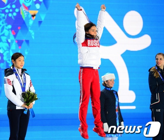 '피겨여왕' 김연아가 22일(한국 시간) 러시아 소치 해안클러스터의 올림픽 파크 내 메달 프라자에서 열린 피겨 여자 싱글 시상식에서 은메달을 목에 걸고 미소짓고 있다. 1위 아델리나 소트니코바(러시아),2위 김연아(대한민국),3위 카롤리나 코스트너(이탈리아)2014.2.22/뉴스1