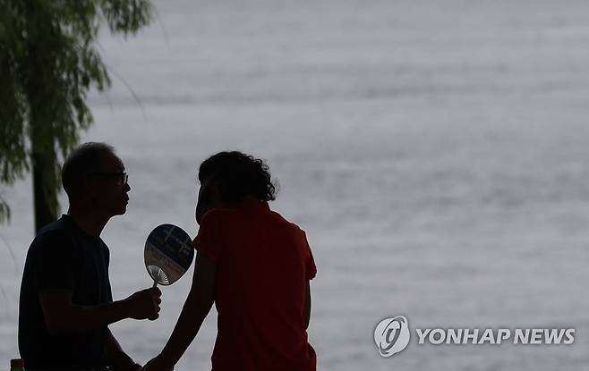 '더위 피해서 그늘로' (서울=연합뉴스) 김성민 기자 = 서울 전역에 폭염 경보가 내려진 6일 오후 서울 영등포구 여의도한강공원에서 시민들이 그늘에 앉아 더위를 피하고 있다. 2023.8.6 ksm7976@yna.co.kr