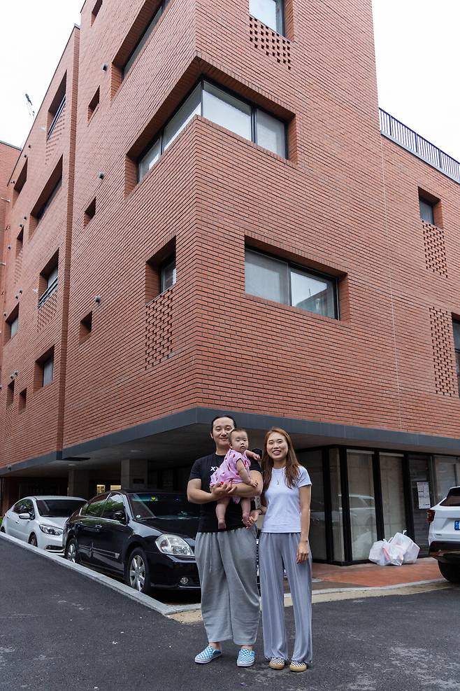 2023년 6월21일 서울 관악구 신림동의 사회주택 ‘에어스페이스 4호점’ 앞에 선 정필운(27·오른쪽), 김도원(28)씨 부부와 아기. 사회주택은 사회적기업이나 협동조합 같은 사회적경제 주체가 공급하는 주택으로, 시세 70~80% 수준의 부담 가능한 임대료로 오랜 기간 살 수 있다.