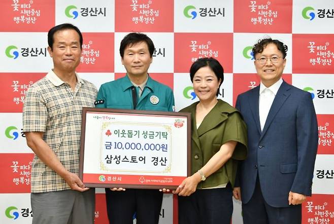 삼성스토어 경산점 손상한, 손지영 공동대표가 조현일 경산시장에게 이웃돕기 성금 1000만원을 전달하고 있다.