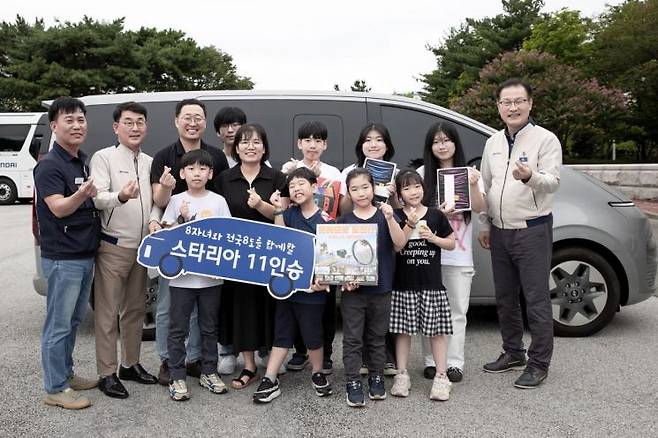 현대차가 9일 전주공장에서 '저출산·육아지원 노사 TFT 간담회'를 진행했다. 노사는 간담회 이후 정기환 기술기사(윗줄 왼쪽에서 3번째) 가족에 스타리아를 증정했다. 정 기사 가족과 현대차 관계자들이 기념 촬영을 하는 모습[사진=현대차]