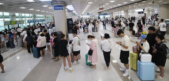 제6호 태풍 카눈이 북상 중인 9일 오전 제주국제공항에서 결항편 승객들이 대체편을 구하기 위해 항공사 안내 데스크 앞에 길게 줄을 서 있다. 뉴스1