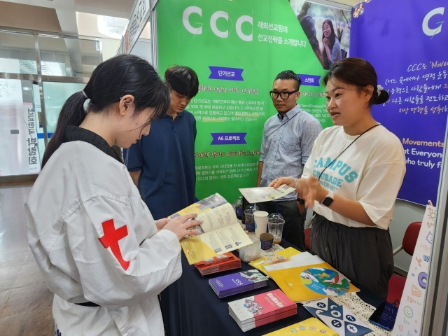 한 참석자가 한국대학생선교회(CCC) 부스에서 선교 정보를 얻고 있다.