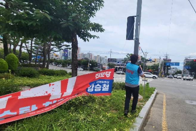 태풍 카눈이 북상하고 있는 가운데 8일 진보당 광주시장이 광주시내에 게시한 현수막을 철거하고 있다. 진보당 광주시당 제공