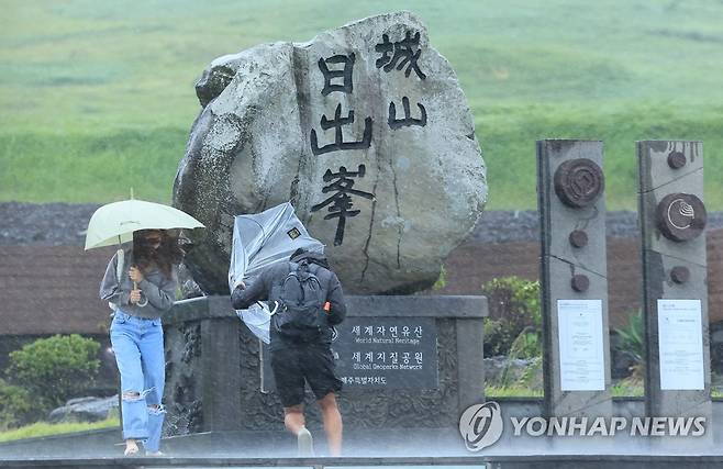 강한 비바람 몰아치는 제주 (서귀포=연합뉴스) 박지호 기자 = 제6호 태풍 카눈이 한반도를 향해 접근 중인 9일 오후 제주 서귀포시 성산일출봉을 찾은 관광객들이 강한 비바람을 맞고 있다. 2023.8.9 jihopark@yna.co.kr