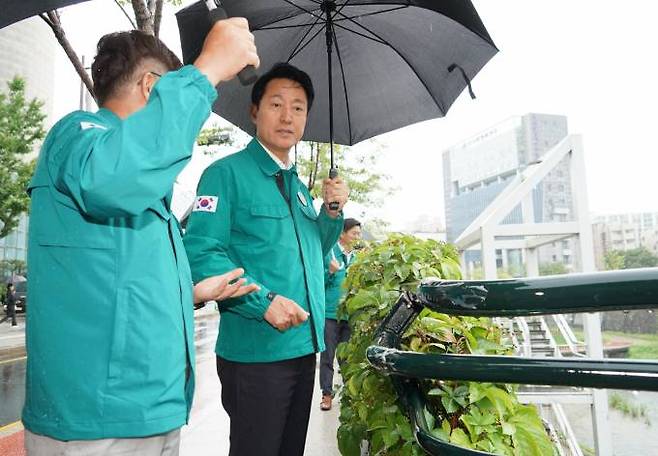 오세훈 시장이 10일 태풍 대비 서울시설공단 앞 청계천을 둘러보며, 하천 수위 및 시민 통제 대응상황 등을 확인하고 있다.   서울시 제공