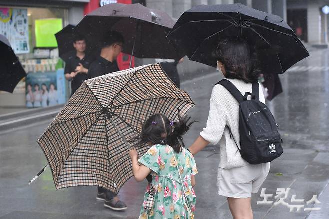 제6호 태풍 '카눈'이 상륙하면서 한반도 전역이 직접적인 영향권에 들어간 10일 서울 종로구 광화문 광장에서 시민들이 비바람을 맞으며 발걸음을 옮기고 있다. 류영주 기자