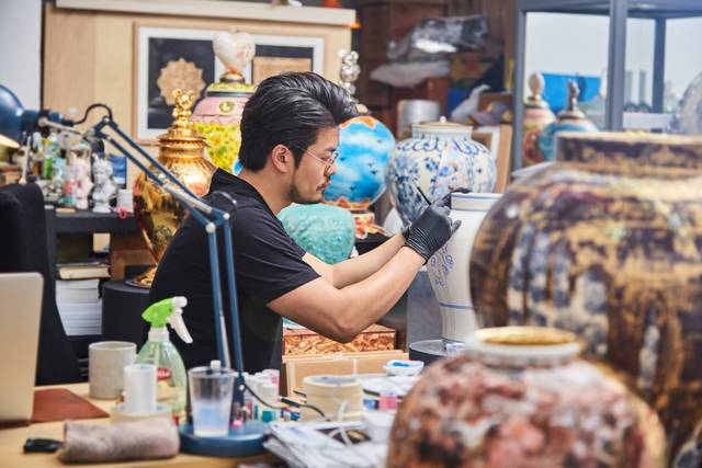 유의정 작가가 도자기에 그림을 그려넣고 있다. 유의정 작가