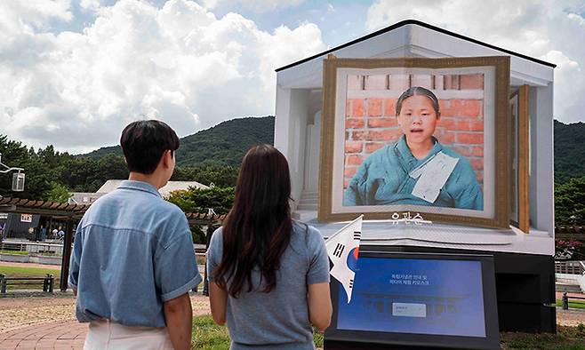 모델들이 10일 독립기념관에서 유관순 열사를 동영상으로 재현한 ‘미디어 파사드’를 관람하고 있다. SK텔레콤 제공