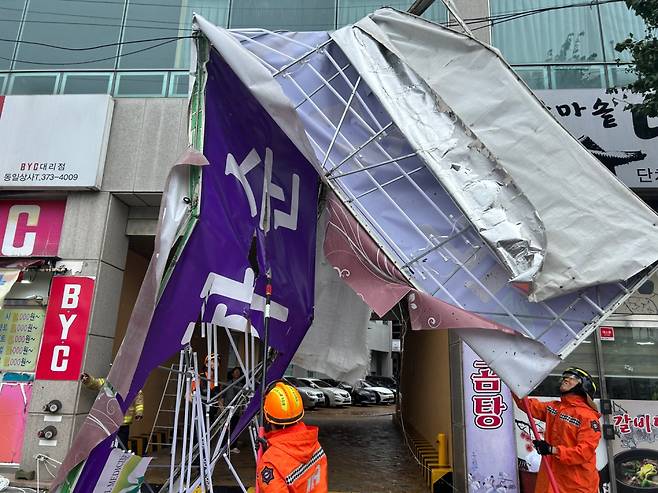 8월10일 전남 화순군 화순읍 향청리의 한 상가 건물 간판이 태풍 카눈이 몰고 온 강풍에 구겨져 뜯기는 사고 발생, 119 구조대가 안전조치하고 있다. ⓒ 전남소방본부 제공