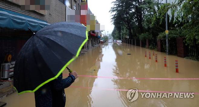 침수된 도로 바라보는 주민 (창원=연합뉴스) 정종호 기자 = 제6호 태풍 카눈이 북상한 10일 오전 경남 창원시 성산구에 시간당 60㎜가 넘는 폭우가 쏟아지면서 내동 한 도로가 물에 잠기자 인근 주민이 이를 바라보고 있다. 2023.8.10 jjh23@yna.co.kr