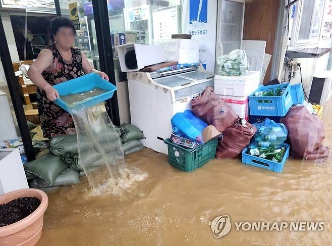 아무리 퍼내도 끝이 없네 (강원 고성=연합뉴스) 양지웅 기자 = 제6호 태풍 카눈의 영향으로 강원 영동지역에 폭우가 쏟아진 10일 고성군 거진읍 거진리에서 상인이 가게에 들어찬 물을 퍼내고 있다. 2023.8.10 yangdoo@yna.co.kr