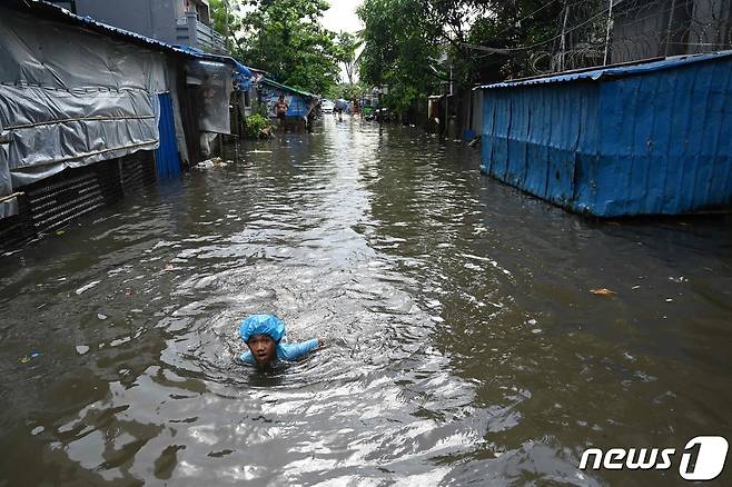 미얀마의 한 소년이 지난 6월말 양곤에 내린 폭우로 마을이 잠기자 수영으로 이동하고 있다. 2023.06.28ⓒ AFP=뉴스1