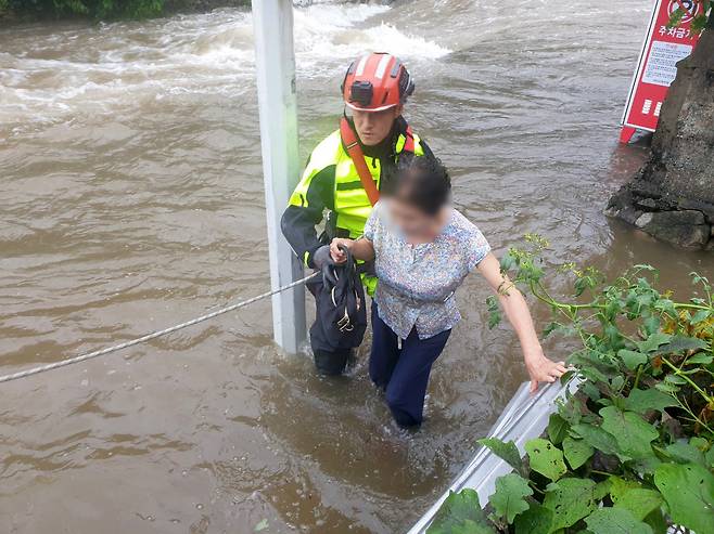 8.10.(목) 오전, 경남 창원시 마산회원구 봉암동에서 불어난 물로 주택에 고립되어 있던 여성을 출동한 소방대원이 구조하고 있다.