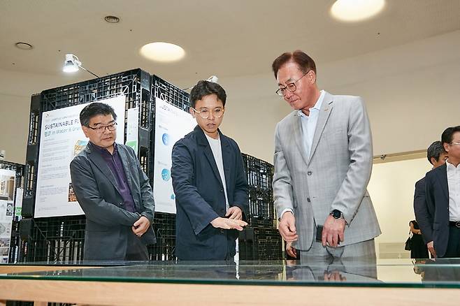 김준 SK이노베이션 부회장(맨오른쪽)이 10일 동대문 행복그린디자인 전시회를 찾아 출품작을 보며 학생·교수진과 의견을 나누고 있다. SK이노베이션