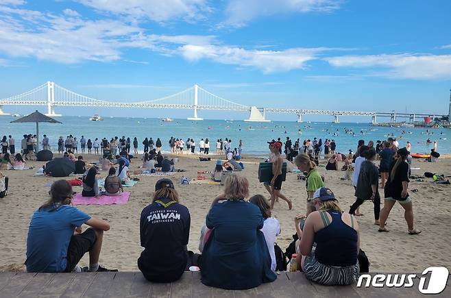 잼버리 대원들이 12일 부산 수영구 광안리해수욕장에서 광안대교를 바라보며 휴식을 취하고 있다.2023.8.12/뉴스1 ⓒ News1 조아서 기자