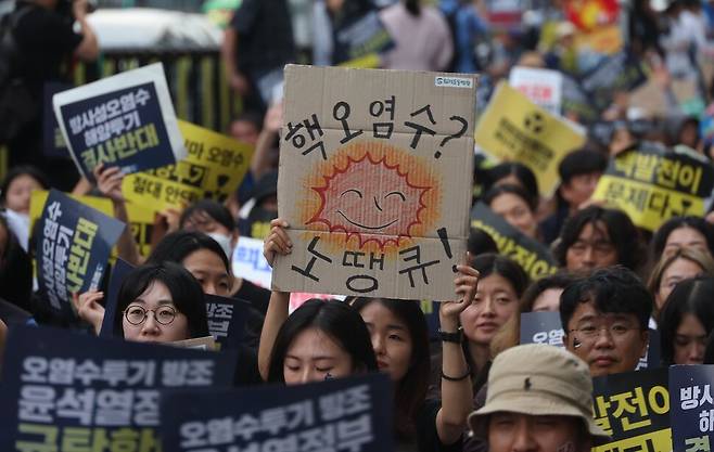 12일 서울 종로구 프레스센터 앞에서 열린 ‘일본 방사성 오염수 해양투기 저지 7차 전국행동’에서 참석자들이 일본 방사성 오염수 해양투기를 반대하는 손팻말을 들고 있다. 강창광 선임기자 chang@hani.co.kr