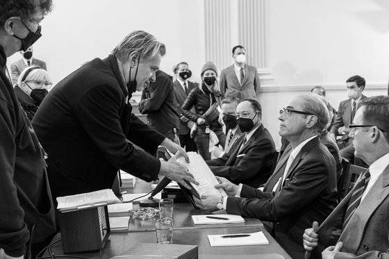 영화 '오펜하이머'(15일 개봉)는 '인터스텔라' '테넷' '다크 나이트' 등을 만든 크리스토퍼 놀런 감독이 각본, 연출을 맡았다. 사진은 놀런 감독이 극중 흑백 화면에 주로 담기는 루이스 스트로스 역할의 배우 로버트 다우니 주니어에게 대본 내용에 대해 상의하는 모습이다. 이 영화를 위해 65mm 흑백 아이맥스 필름을 특별 제작하기도 했다. 사진 유니버설 픽쳐스