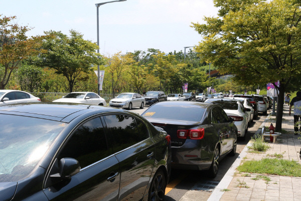 13일 부산 기장군 국립부산과학관에 진입하려는 차량(왼쪽)과 주차할 곳이 없어 과학관 바깥에 주차한 차량. 국립부산과학관 제공