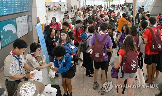 '잼버리 폐영' 출국 시작 (서울=연합뉴스) 12일 오전 인천국제공항에서 세계스카우트 잼버리 대원들이 출국 전 선물을 받고 있다. 2023.8.12 [공항사진기자단] photo@yna.co.kr