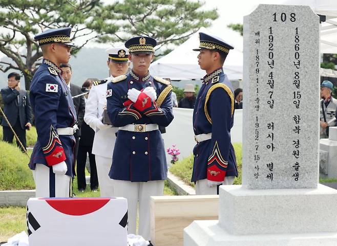 제78주년 광복절을 하루 앞둔 14일 서울 동작구 국립서울현충원 애국지사 묘역에서 거행된 독립운동가 최재형 선생과 최 엘레나 여사의 부부 합동안장식에서 국방부 의장대가 영현 감쌌던 태극기를 유가족에게 전달하고 있다. 사진=공동취재단