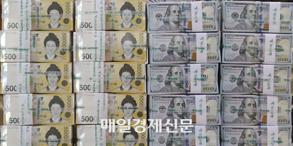 South Korea’s 50,000 won banknotes, left, and U.S. 100 dollar banknotes. [Photo by Han Joo-hyung]