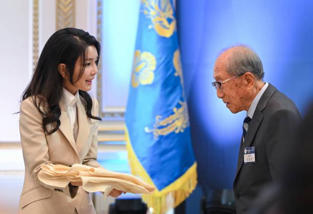 ▲윤석열 대통령 부인 김건희 여사가 8월 9일 청와대 영빈관에서 열린 독립유공자 및 유족 초청 오찬에서 김영관 애국지사에게 무궁화 자수 한산모시 적삼을 선물하고 있다. ⓒ연합뉴스